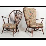 A pair of Ercol beech and elm wood Windsor pattern armchairs raised on turned legs with stretchers