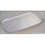 A sterling silver salver marked 925 of rectangular form with gadrooned edges.