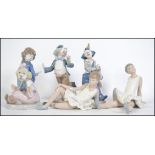 A group of Lladro Nao ceramic figures to include four clown figures together with a pair of ballet