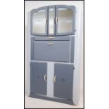 A vintage 1950's retro kitchen dresser cabinet having mottled glass cupboard to top over fall front