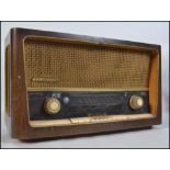 A vintage mid 20th century wooden cased Grundig valve radio. Model 3028 / GB AM / FM receiver.