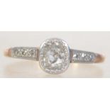 An 18ct gold and diamond ladies ring having diamond set shoulders surrounding the oval old cut