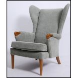 A good quality 20th century Parker Knoll wingback armchair raised on cabriole legs with pad feet,