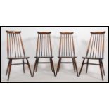 A set of 4 Ercol beech and elm Goldsmiths dining chairs with railed back rests over saddle seats