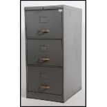 A vintage mid 20th century three drawer grey painted filing cabinet with brass style ribbed handles.