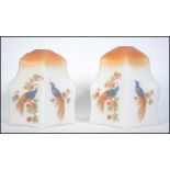 A pair of 1930's Art Deco glass light shades being decorated with birds of paradise and fauna