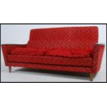 A 1960's Danish influence sofa day / bed raised on tapered legs having teak and original moquette