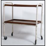 A vintage 1950's tubular metal and teak tray trolley having 2 tiers with painted white finished -