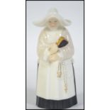 A royal Worcester candle snuffer in the form of a nun.