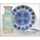 A group of two Chinese blue and white plates/ chargers along with a Japanese vase ( AF ) all dating