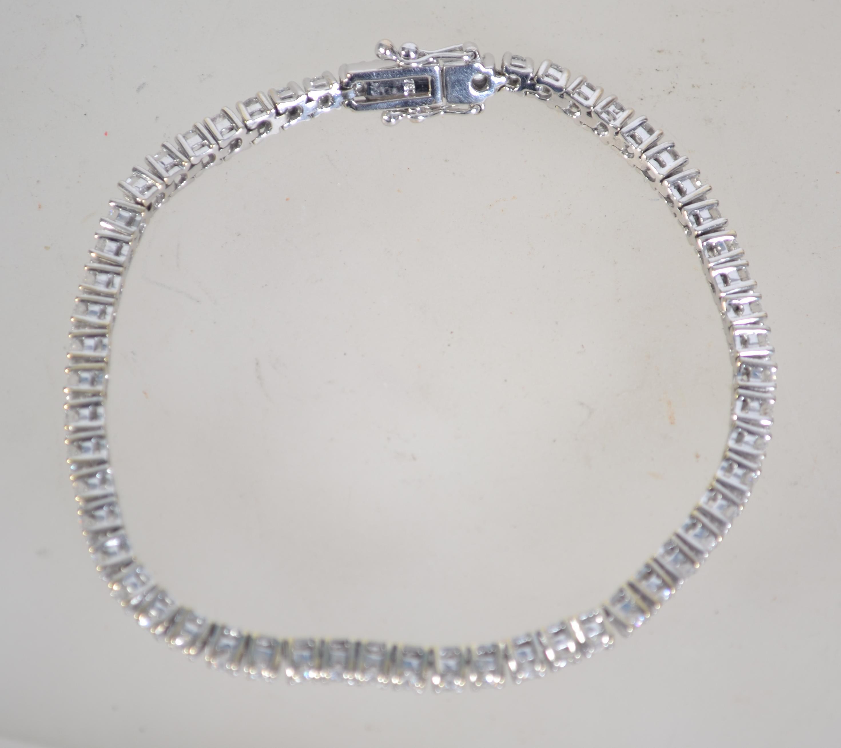 A hallmarked 18ct white gold and diamond tennis bracelet set with a total of 3cts diamonds. - Image 7 of 8