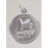 A 925 silver Georg Jensen circular silver pendant cast with Viking long boat.