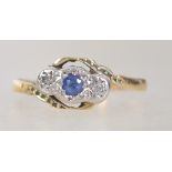 An 18ct gold, sapphire and diamond ring. The central sapphire flanked by diamonds in star settings.