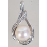 A hallmarked 9ct white gold diamond and peal pendant with crossover bale. Measures 2cms.