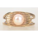 A vintage hallmarked 9ct gold and single pearl ring set with a central pearl on a scalloped lozenge