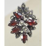 A silver 925 oversized ladies cluster dress ring set with marcasite and glass garnet stones.