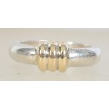 A 950 silver ladies dress ring with yellow metal ribbed centre.