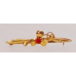 A 9ct gold bar brooch with 3 leaf clover motif set with central red stone with C clasp.