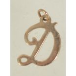 A 9ct gold pendant charm in the form of the letter D. Marked 9ct tests 9ct gold. Measures 1.5cms.