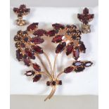 A vintage rhinestone set weeping flower brooch and earring suite set with marquise and round cut