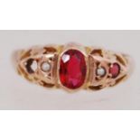 An early 20th century 9ct gold ring set with pearls and red stones. Small red stone missing.