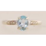 A 9ct gold ring set with diamonds and a central blue stone. Size L. Tests 9ct gold.