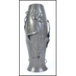 An early 20th century pewter vase embell