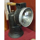 A painted metal carbide hand lamp with turned wooden handle, 32cm high.