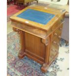 A late-Victorian walnut Davenport, the hinged writing slope above four side drawers and four