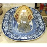 A large blue and white 'Wild Rose' pattern meat plate decorated with a rustic scene of a cottage