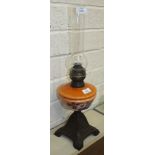 A late-Victorian oil lamp, the orange opaque glass reservoir on metal base, 60cm high overall.