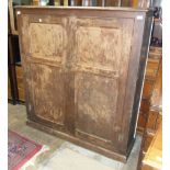 A stained pitch pine two-door cupboard fitted with shelves, 123cm wide, 138cm high, (back