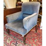 An Edwardian upholstered armchair with turned wood front legs.