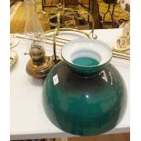 A brassed hanging fitting with oil lamp, green glass shade and three hanging rods.