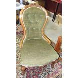 A Victorian mahogany-framed salon chair with upholstered seat and button back, on shaped front