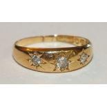 An 18ct gold gipsy ring set three diamonds, size L½, 2.6g.