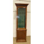 A hardwood gun cabinet, the moulded and dentil cornice above a single bevelled glass door, enclosing