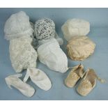 A pair of baby shoes of ivory silk with silk embroidery, rosettes and edging and leather soles, a