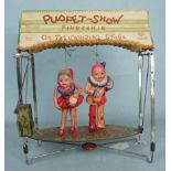 A Japanese CK trademark 'Puppet-Show' tinplate and celluloid clockwork toy c1930's, the card roof