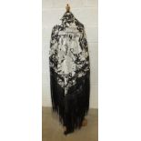 A Chinese black silk piano shawl with ivory silk embroidered floral and pagoda design and deep