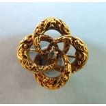 A 14k gold brooch of four linked rings centred by a brilliant-cut diamond, 2cm diameter, 3g.