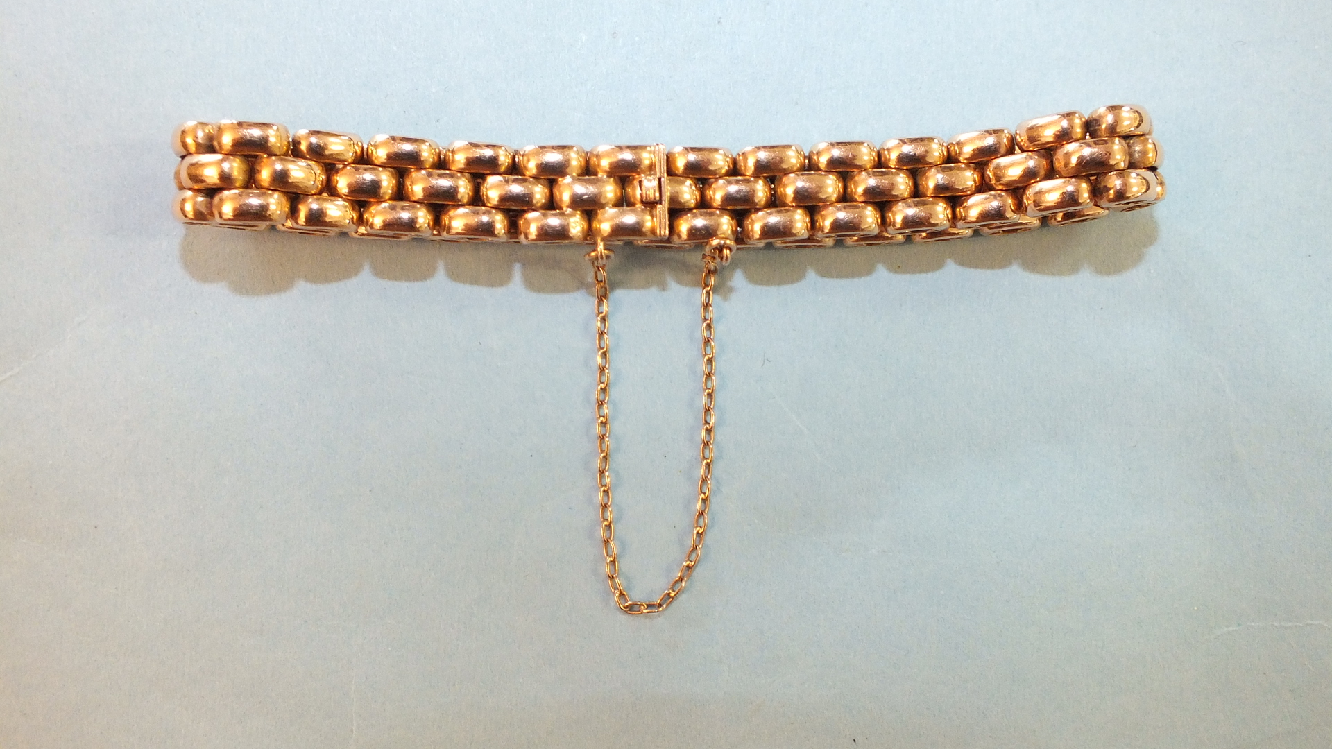 A rose gold bracelet of rounded brick links with concealed clasp and safety chain, 26.5g.