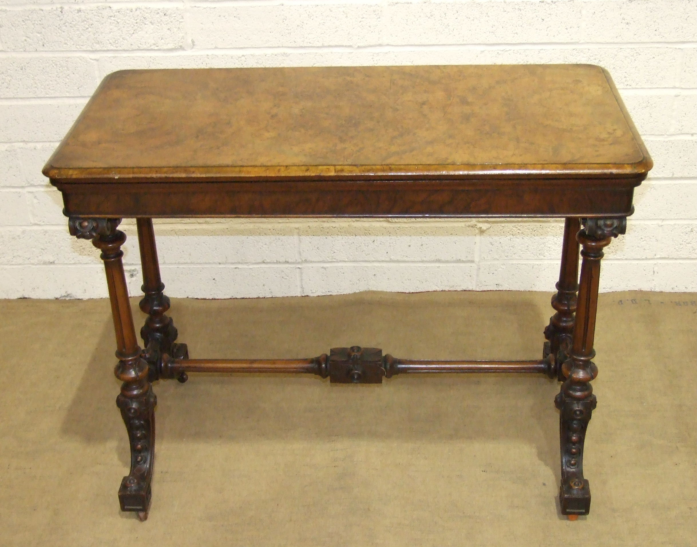 A Victorian figured walnut card table, the fold-over rectangular top raised on fluted and turned