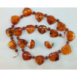 An amber necklace of seventeen leaf-shaped plaques, (one with small fly inclusion), with amber beads