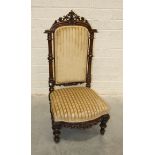 A Victorian walnut carved high-back nursing chair on turned feet, 112cm high.