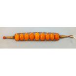 An ethnic amber bracelet of nine graduated amber beads on metallic thread mount, 17cm, 16.7g.