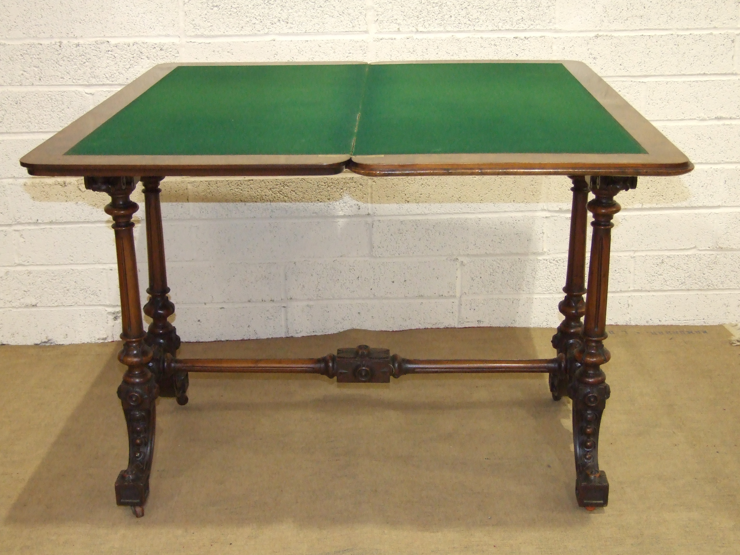 A Victorian figured walnut card table, the fold-over rectangular top raised on fluted and turned - Image 2 of 2