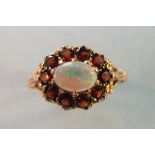 A garnet and opal cluster ring set ten round-cut garnets around an oval opal, in 9ct gold mount,