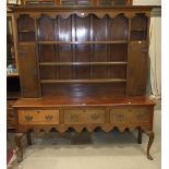 An oak dresser in the George III style, the plate rack with two cupboard doors above three drawers