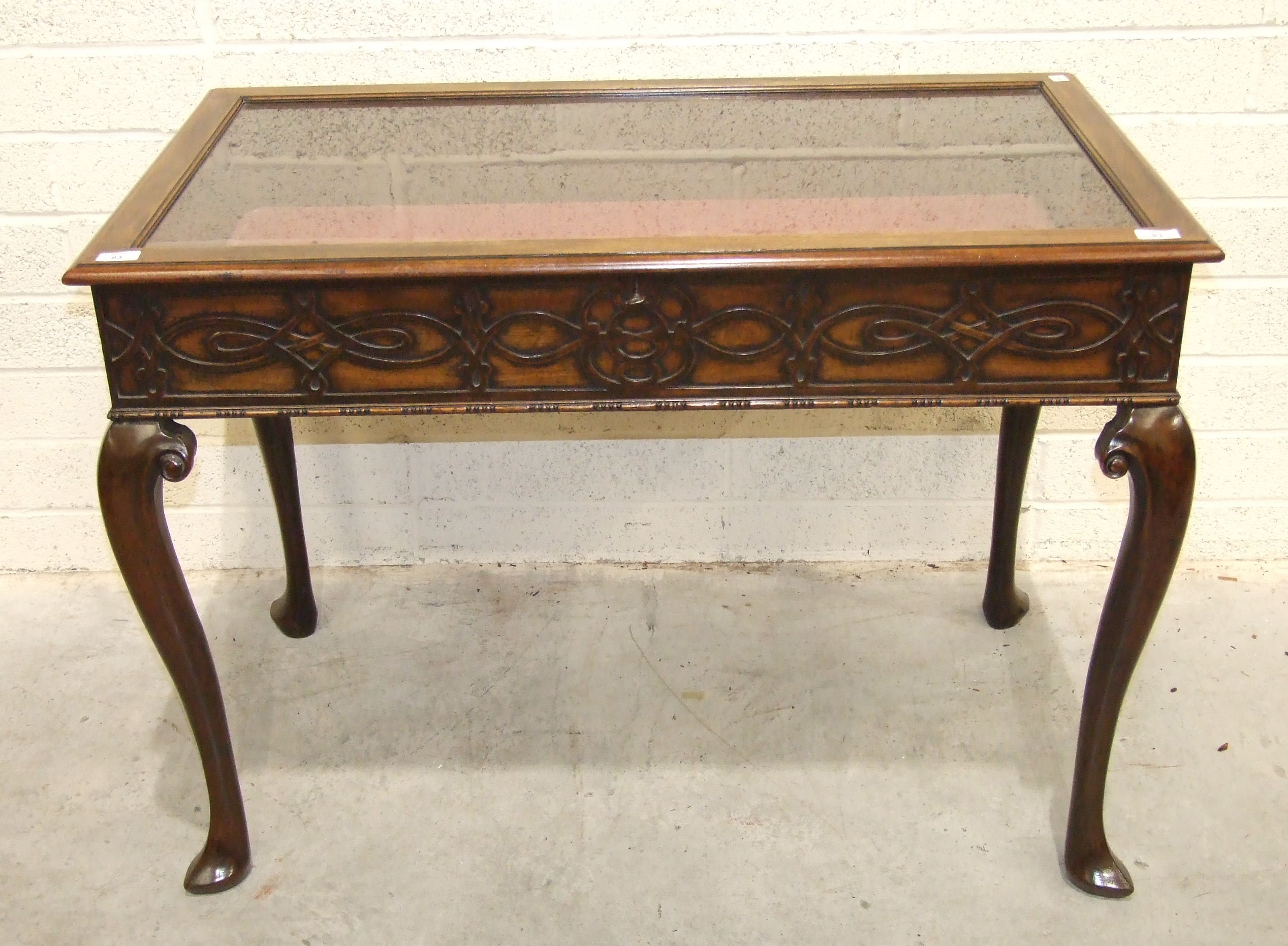 A 20th century mahogany display table, the glazed top with blind fret frieze on cabriole legs, 105